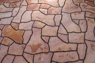 Modern flagstone mosaic tiles slabs with random chaotic texture for stone wall ,patio floor or terrace construction. Abstract background of brown sandstone slabs with cracked lines on garden walkway.