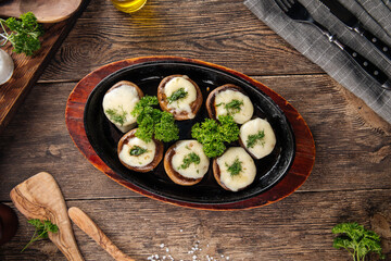 Baked stuffed champignon hats in a pan
