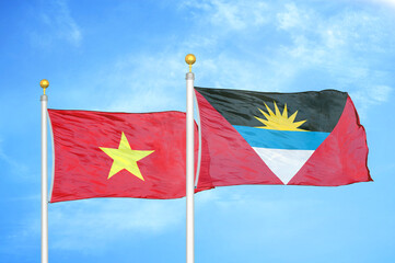 Vietnam and Antigua and Barbuda  two flags on flagpoles and blue sky