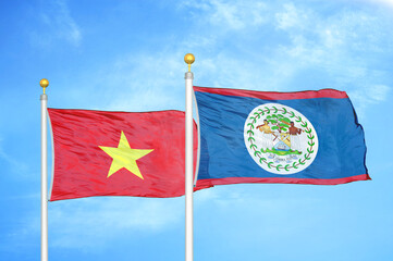 Vietnam and Belize  two flags on flagpoles and blue sky