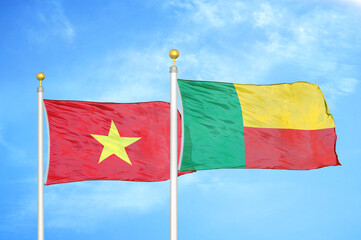 Vietnam and Benin two flags on flagpoles and blue sky
