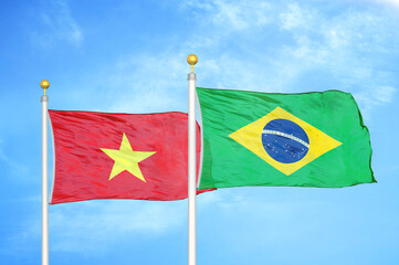 Vietnam and Brazil  two flags on flagpoles and blue sky
