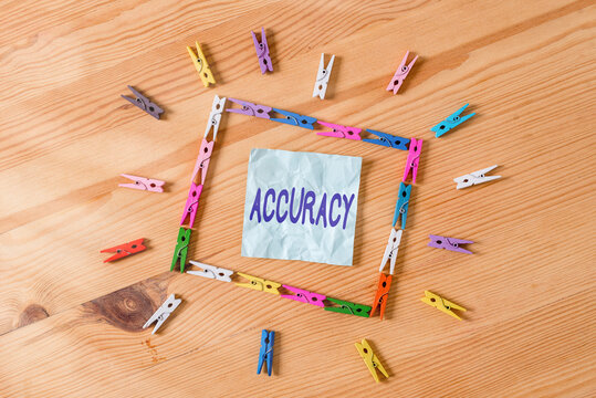 Handwriting text Accuracy. Conceptual photo degree of conformity of a measure to a standard or a true value Colored clothespin papers empty reminder wooden floor background office