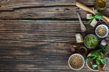 ingredients to cook homemade italian sauce pesto basil, garlic, parmigiano, olive oil and pine nuts horizontale