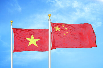 Vietnam and China two flags on flagpoles and blue sky