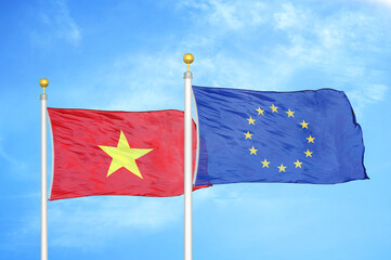 Vietnam and European Union two flags on flagpoles and blue sky