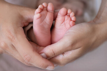 Obraz na płótnie Canvas newborn baby feet in hand