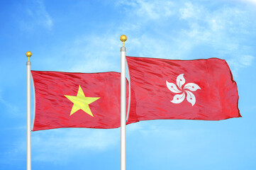 Vietnam and Hong Kong two flags on flagpoles and blue sky