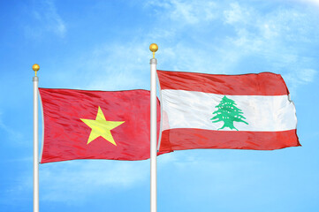 Vietnam and Lebanon two flags on flagpoles and blue sky