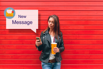 woman with the phone and a drink in hand reads the message