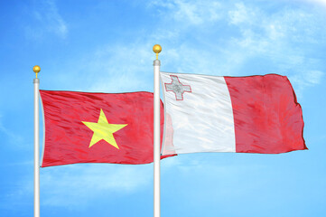 Vietnam and Malta two flags on flagpoles and blue sky