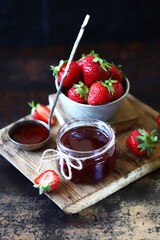 Selective focus. Jar of strawberry jam. Fresh strawberries. Strawberry jam cooking concept.