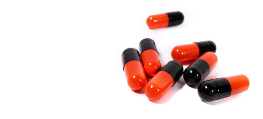 red and black antibiotics medicine capsules isolated on white background. BANNER WITH SPACE FOR TEXT WITH LEFT