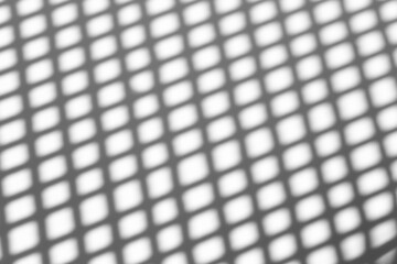 Shadow overlay effect for photo.  Shadows from grid lines or grating of a fence or guardrail on a clean white wall on a sunny clear day. Geometric shadows