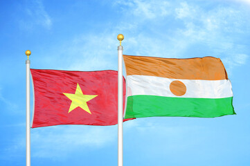 Vietnam and Niger two flags on flagpoles and blue sky