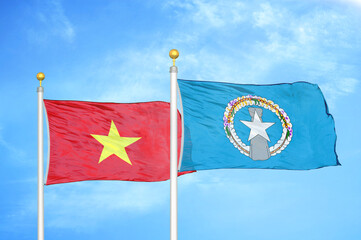 Vietnam and Northern Mariana Islands two flags on flagpoles and blue sky