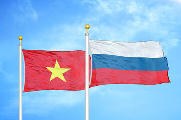 Vietnam and Russia two flags on flagpoles and blue sky