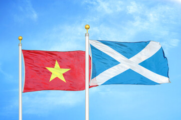 Vietnam and Scotland two flags on flagpoles and blue sky