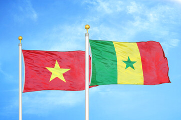 Vietnam and Senegal two flags on flagpoles and blue sky