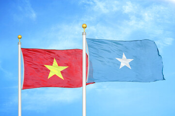Vietnam and Somalia two flags on flagpoles and blue sky