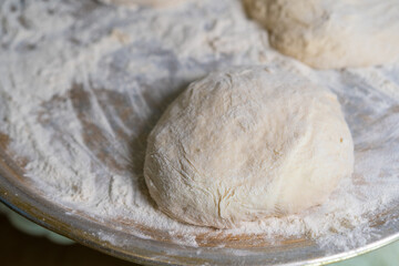 The dough piece is on the surface with flour