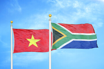 Vietnam and South Africa two flags on flagpoles and blue sky