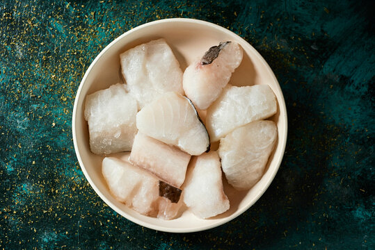 pieces of frozen uncooked codfish in a plate