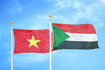 Vietnam and Sudan two flags on flagpoles and blue sky