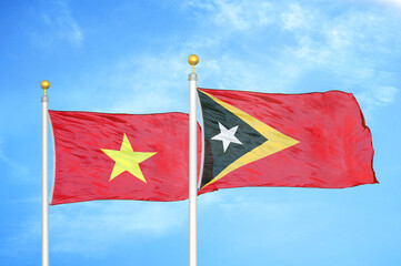 Vietnam and Timor-Leste East Timor two flags on flagpoles and blue sky