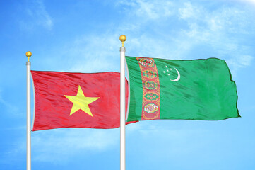 Vietnam and Turkmenistan two flags on flagpoles and blue sky