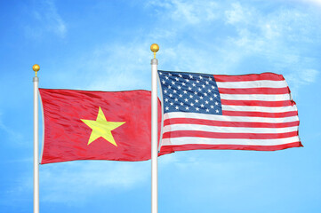 Vietnam and United States two flags on flagpoles and blue sky