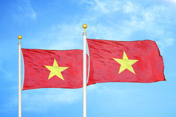 Vietnam two flags on flagpoles and blue sky