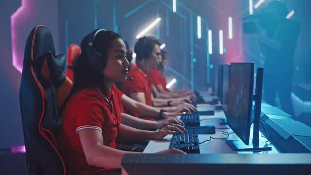 Pro Girl Plays Computer Game Plays RPG Strategy on a Championship, Celebrate Winning Round. Diverse Esport Team of Pro Gamers Play in Mock-up Video Game. Stylish Neon Cyber Games Arena