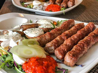 grilled meatballs and potatoes with salad on plate
