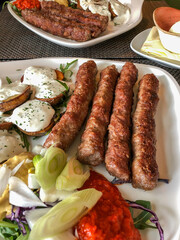 grilled meatballs and potatoes with salad on plate
