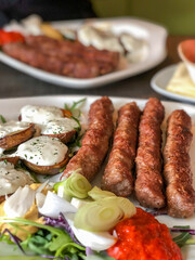 grilled meatballs and potatoes with salad on plate