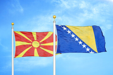 North Macedonia and Bosnia and Herzegovina two flags on flagpoles and blue sky