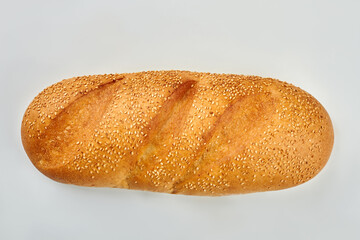 Sesame seeds on french bread. Loaf of french bread isolated on white background. Delicious food for breakfast.