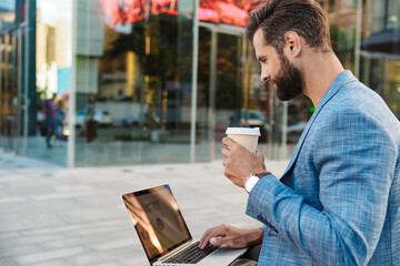 Attractive young bussiness man working on laptop