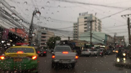 Colorful bokeh with street light at night rainy day,blurred view,drive car on the road in the lot rain.
