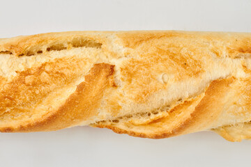 Close up of fresh french baguette with crust. Crispy french bread texture. Isolated on white background.