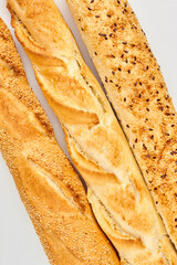 Three baguettes on white background. Freshly baked bread, top view. Crusty french baguette recipe.