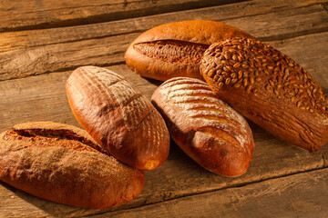 Wholemeal wheat bread on wooden background. Healthy bread with crust on table. Organic food concept.