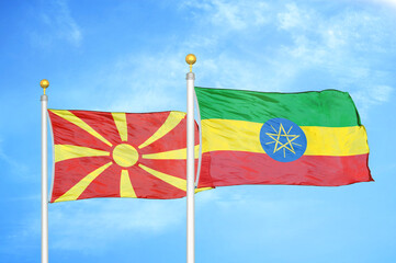 North Macedonia and Ethiopia two flags on flagpoles and blue sky