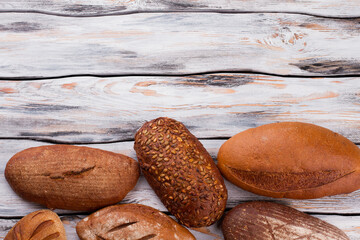 Wholemeal wheat bread loaves and copy space. Homemade bread loaves on vintage wooden background.