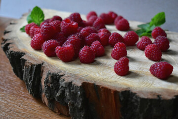 ripe raspberries on a piece natural wood