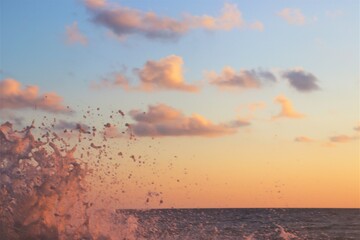 From the sunset colored water splash shooting into the sky from the lower left corner