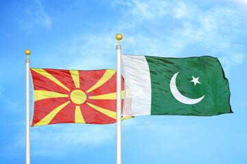 North Macedonia and Pakistan two flags on flagpoles and blue sky