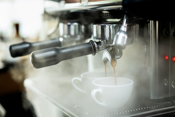 Coffee machine espressos shot and smoke in white cups .