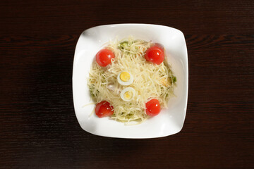 Tender delicious salad with cheese decorated with quail eggs, top view. Photos for restaurant and cafe menus